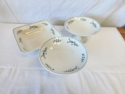 three bowls and a plate sitting on a white table