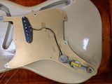 an overhead view of a white electric guitar in a wooden case