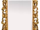 un miroir doré richement décoré, avec un fond blanc et un cadre doré