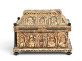 an image of a gold colored box with carvings on it
