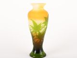 un vase en verre orné d'une plante, posé sur une surface blanche
