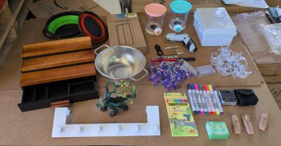 une table sur laquelle se trouvent de nombreux objets, notamment des ciseaux, des stylos, des ciseaux et d'autres objets