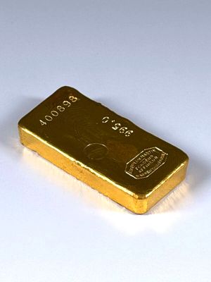 un lingot d'or posé sur une surface blanche
