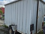 a man standing next to a trailer in a parking lot