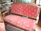 a pink couch and two chairs in a room