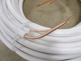 a coil of white hose with copper wire on it