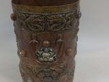a small metal cup with a design on it