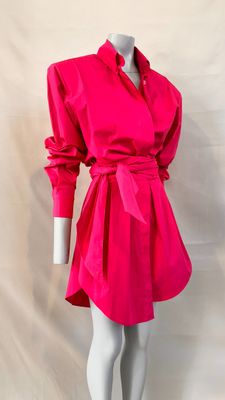 the mannequin is wearing a bright pink dress with a belt