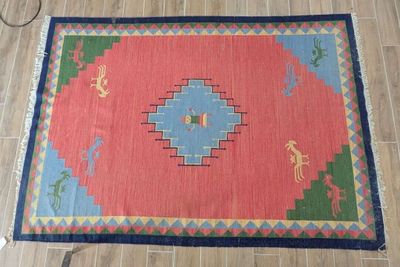 a red and blue rug on a wooden floor