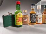 many different types of alcohol bottles and flasks on the table