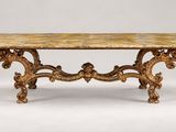 une table richement sculptée, avec un plateau en marbre sur fond blanc