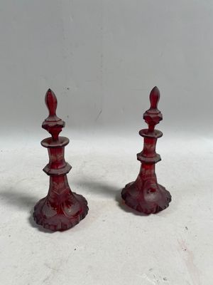 une paire de bougeoirs en verre rouge sur fond blanc