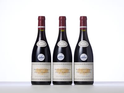 trois bouteilles de vin rouge posées sur une table