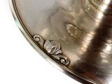 a silver candle holder on a white table