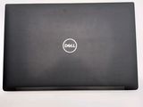 the dell laptop is sitting on a white surface with a black cover