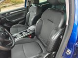 the interior of a blue car with black leather seats and a steering wheel
