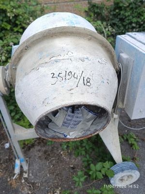 a cement mixer sitting on the side of the road
