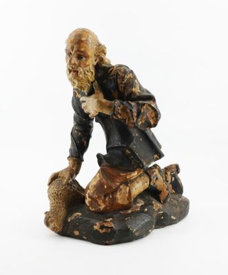 figurine of an old man sitting on a rock with a dog