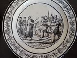 a black and white plate with a picture of people on it