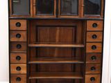 une grande armoire en bois comportant de nombreux tiroirs et étagères