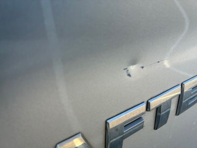 un gros plan sur l'emblème d'une voiture, sur le côté de celle-ci