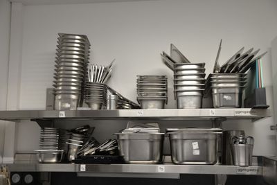 many pots and pans on the shelves in the kitchen