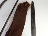 a knife, a cane, and a cloth bag on a table