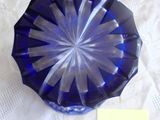 un bol en verre bleu posé sur une table, sur lequel est posée une note