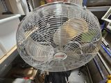 a man standing next to a large fan in a room