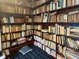 a bed that is in front of a bookshelf full of books