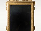 un miroir avec un cadre doré sur fond blanc