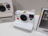 a polaroid camera sitting on a table next to a box of polaroid