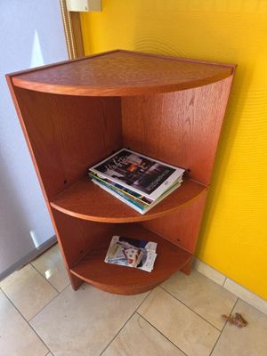 une étagère d'angle sur laquelle sont posés des magazines