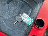a key on the back of a red car