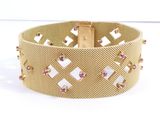 a close up of a gold bracelet with pink stones