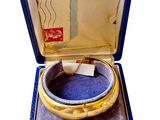 une bague en or dans une boîte bleue sur fond blanc