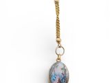 a close up of a necklace with a bird on it