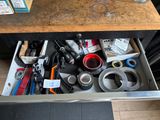 a drawer full of assorted tools on a kitchen counter