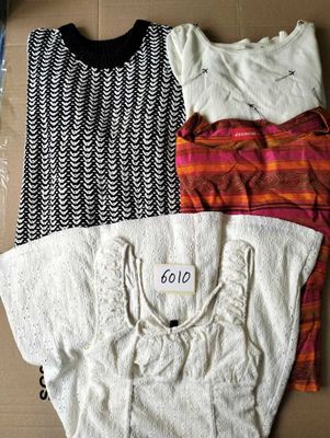 three shirts are sitting on top of a cardboard box on a table