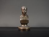 un buste en bronze représentant un homme assis sur une table