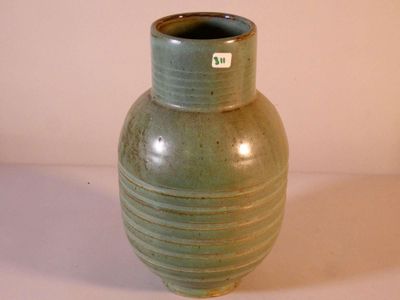 un vase vert posé sur une table