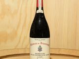 une bouteille de vin posée sur un tonneau