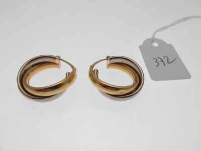 une paire de boucles d'oreilles en or sur fond blanc