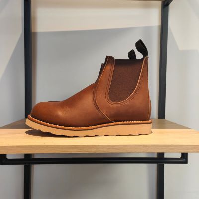 une paire de bottes marron posée sur une étagère en bois