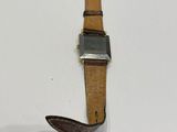 an image of a watch with a leather strap on a white surface