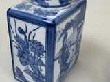 a blue and white vase with a lid on a table