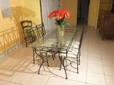 une table en verre sur laquelle se trouve un vase de fleurs