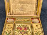 une vieille boîte en bois contenant quatre morceaux de papier