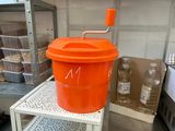 an orange bucket with a handle sitting on a shelf