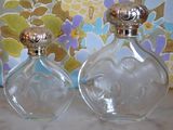 deux flacons de parfum posés l'un à côté de l'autre sur une table